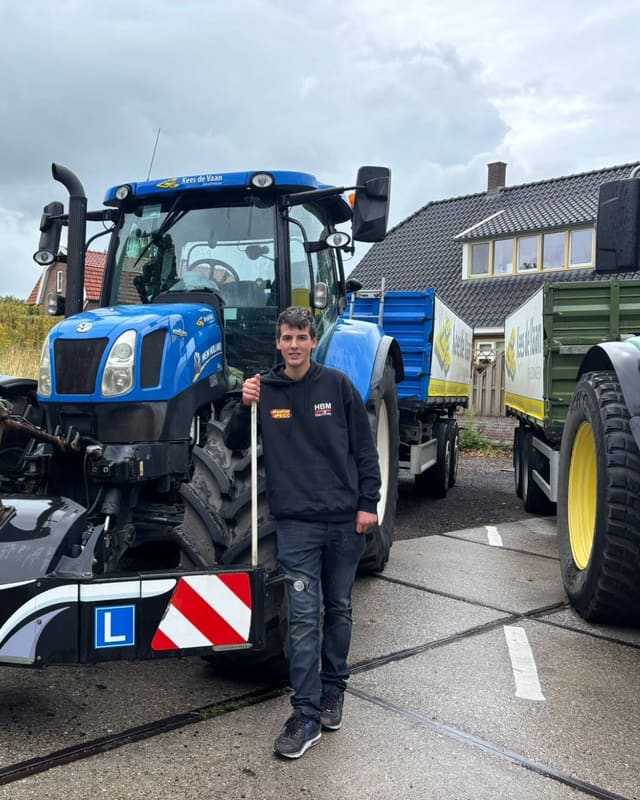 Geslaagde cursist bij de voorkant van een blauwe lestrekker met L-bord