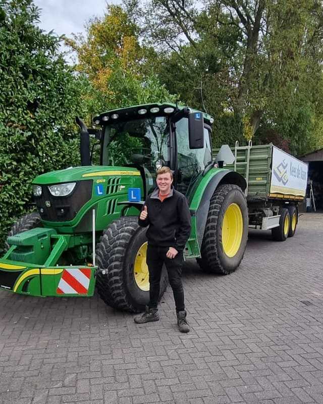 Geslaagd voor het trekkerrijbewijs: cursist steekt duim op bij een groene lestrekker